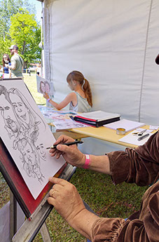 Karikaturista Janko při rychlokresbě na firemní akci, zábavný doprovodný program pro hosty večírku.