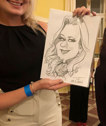 Spokojená zákaznice drží hotovou karikaturu: ukázka věrného zachycení podoby od Janka Toraka.