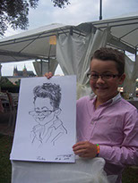 Malý kluk drží svou karikaturu od Karikaturisty Janka, nakreslenou na akci v restauraci Nebozízek v Praze